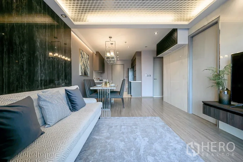 Condominium for rent in Watthana, Bangkok - Open-plan living and dining area with modern kitchen, pendant lighting, and wood floors.