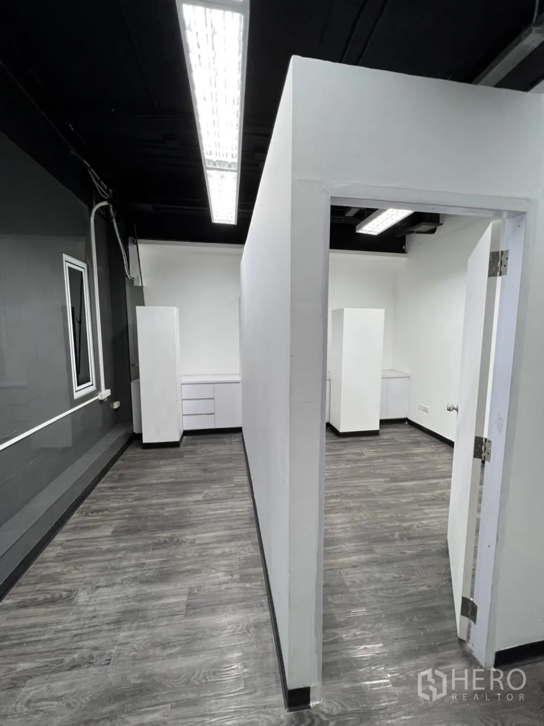 พื้นที่ขายปลีก ให้เช่าในSathon, Bangkok - พื้นที่ทำงานกั้นห้อง ผนังสีขาว เพดานสีดำ และพื้นลายไม้สีเทา