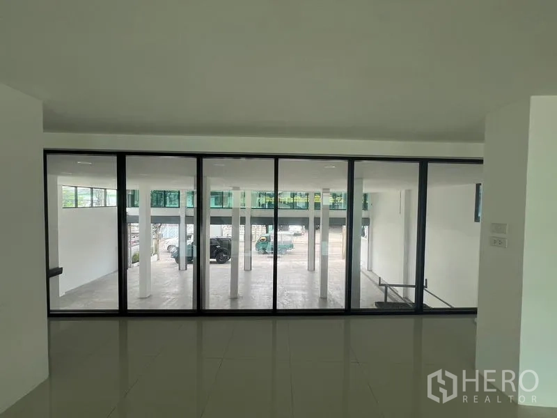 Office Space for rent or sale in Wang Thonglang, Bangkok - Interior glass wall overlooking the carport and driveway.