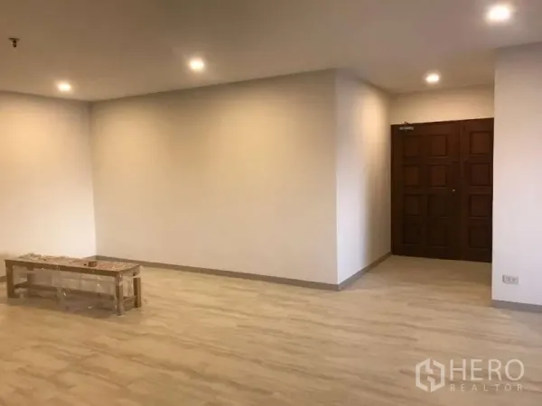 คอนโด ขายในWatthana, Bangkok - ห้องนั่งเล่นกว้าง พื้นลามิเนตสีอ่อน ไฟฝังฝ้า และประตูไม้ทึบ