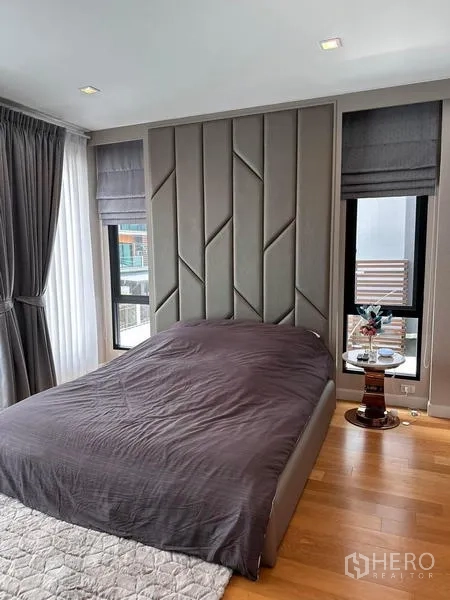 独立式住宅 出租在Prawet, Bangkok - 转角卧室，几何软包床头与落地窗。