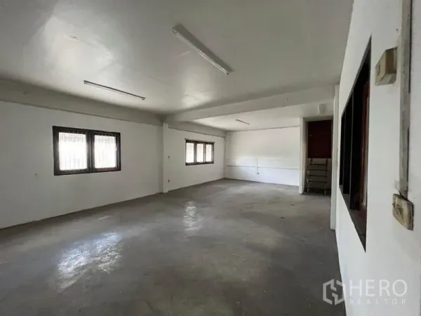 Warehouse for rent in Khlong Toei, Bangkok - Secondary workspace with barred windows and fluorescent strip lighting.