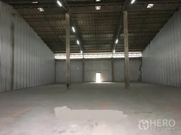 คลังสินค้า ให้เช่าในBang Phli, Samut Prakan - ฮอลล์โกดังกว้างแบบคานช่วงยาว มีเสากลาง ไฟสว่างทั่วถึง และประตูทางออกด้านหลัง