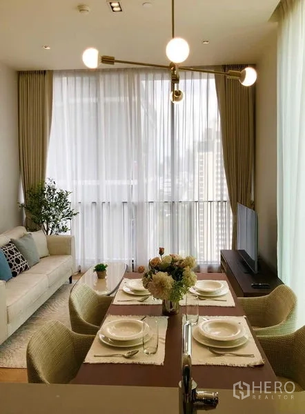Condominium for rent - Dining area set for four beside full-height windows and a modern pendant light.