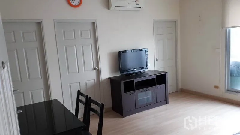 Condominium for rent in Bang Rak, Bangkok - Living and dining area with TV console, dining set, air conditioner and multiple interior doors.