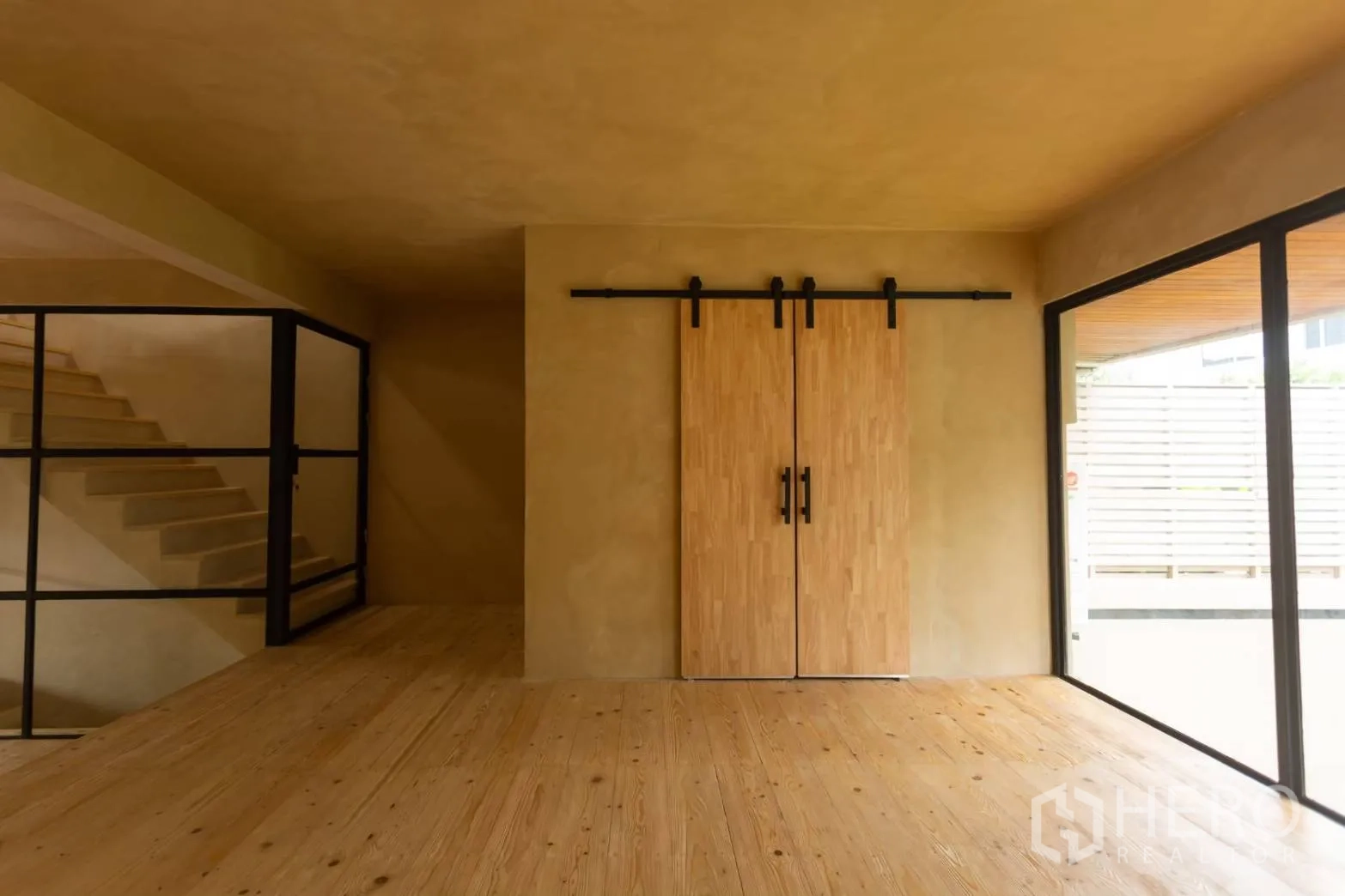 Home Office for rent in Watthana, Bangkok - Close view of sliding barn doors, floor‑to‑ceiling glass and natural wood floors.