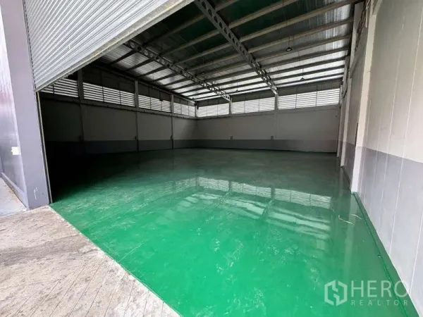 โรงงาน ให้เช่าหรือขายในLam Luk Ka, Pathum Thani - ประตูม้วนเปิดโชว์พื้นที่โกดังโล่งกว้างและผนังระบายอากาศ