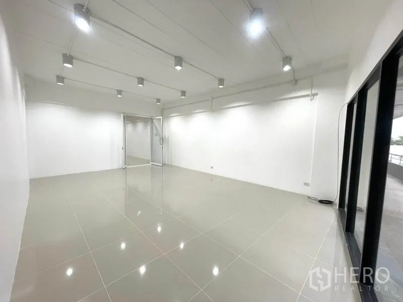 办公空间 出租在Khlong Toei, Bangkok - 从玻璃立面内看开放式办公室，天花灯明亮，地面光洁。