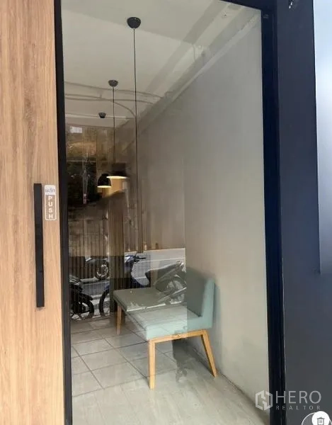 พื้นที่ขายปลีก ให้เช่าในWatthana, Bangkok - มุมประตูกระจก เห็นเก้าอี้นั่งรอและโคมไฟห้อยภายในร้าน