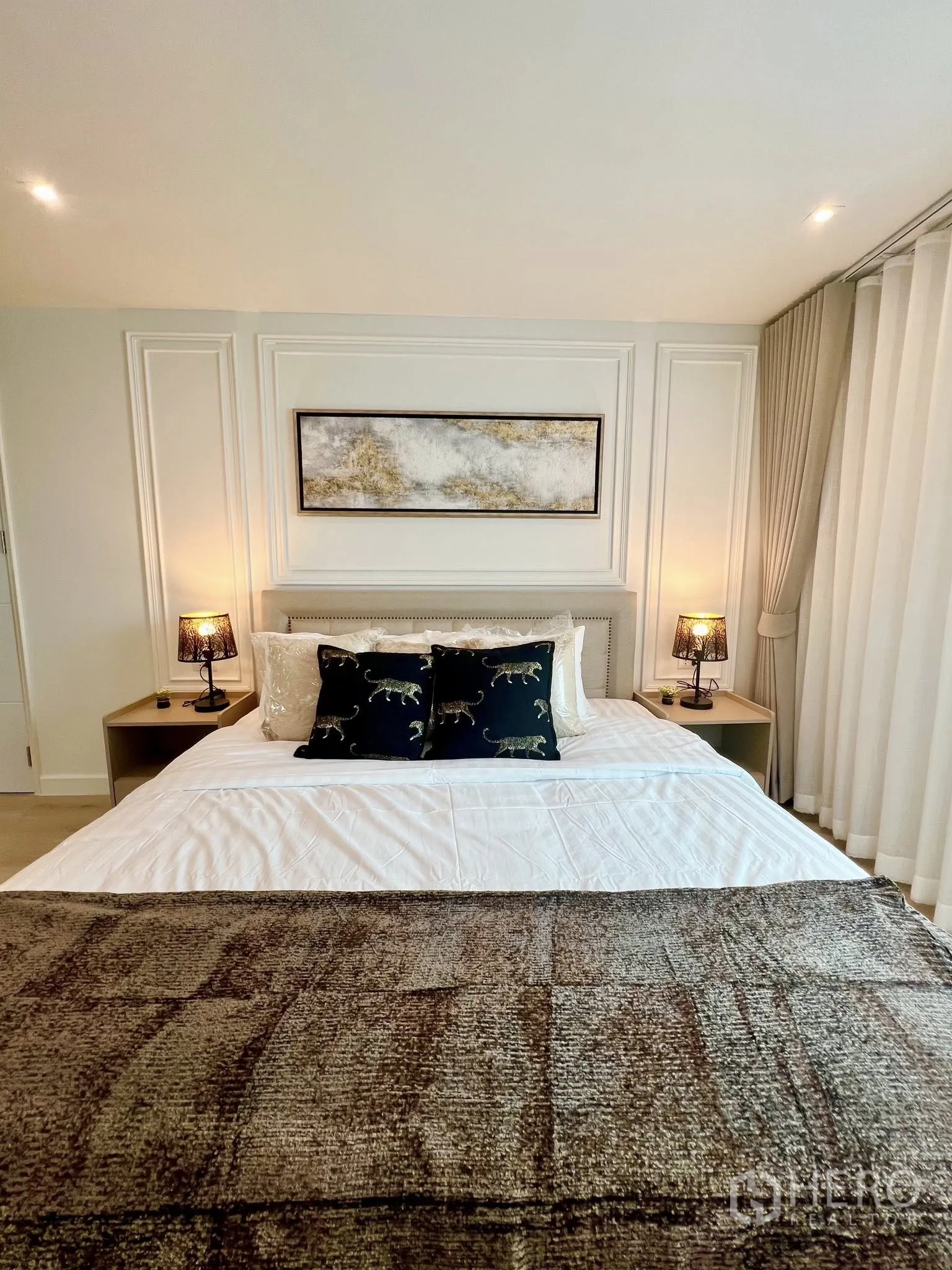 Condominium for rent or sale in Yan Nawa, Bangkok - Elegant bedroom with artwork above the bed, bedside lamps and layered curtains.