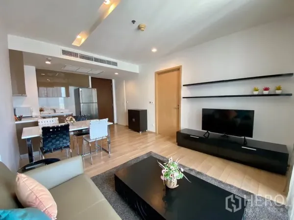 คอนโด ให้เช่าในKhlong Toei, Bangkok - ห้องนั่งเล่นมีชั้นวางลอย ทีวีคอนโซล และโซฟารับแสงจากระเบียง