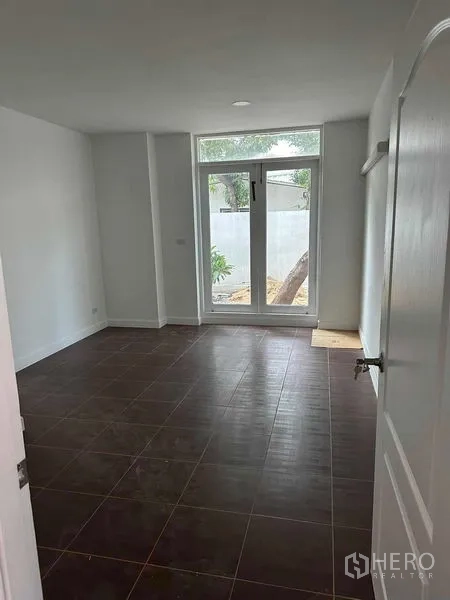 Home Office for sale - Ground-floor bedroom or office with dark tiles and a tall glass door opening to the garden.