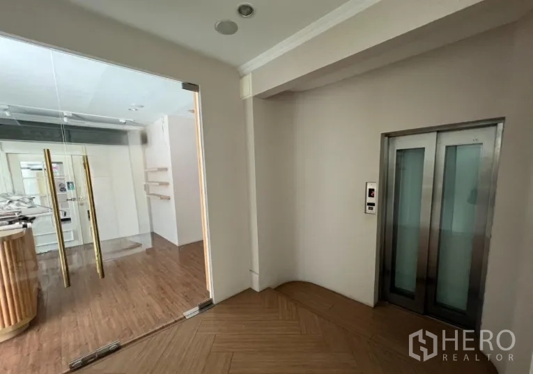 พื้นที่ขายปลีก ให้เช่า - โถงลิฟต์พร้อมประตูกระจกเข้าสู่ยูนิต พื้นไม้ก้างปลา