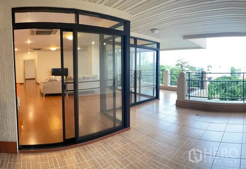 公寓 出租在Watthana, Bangkok - 超大覆盖式露台，地砖铺设，黑框玻璃，绿意景观。