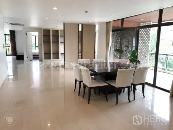 Condominium for rent or sale in Watthana, Bangkok - Spacious dining zone beside built-in shelving and sliding glass doors to the terrace.