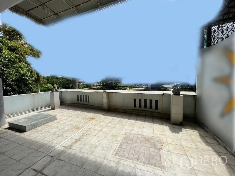 Townhouse for rent in Khlong Toei, Bangkok - Spacious upper terrace with tiled floor, partial roof and green views.