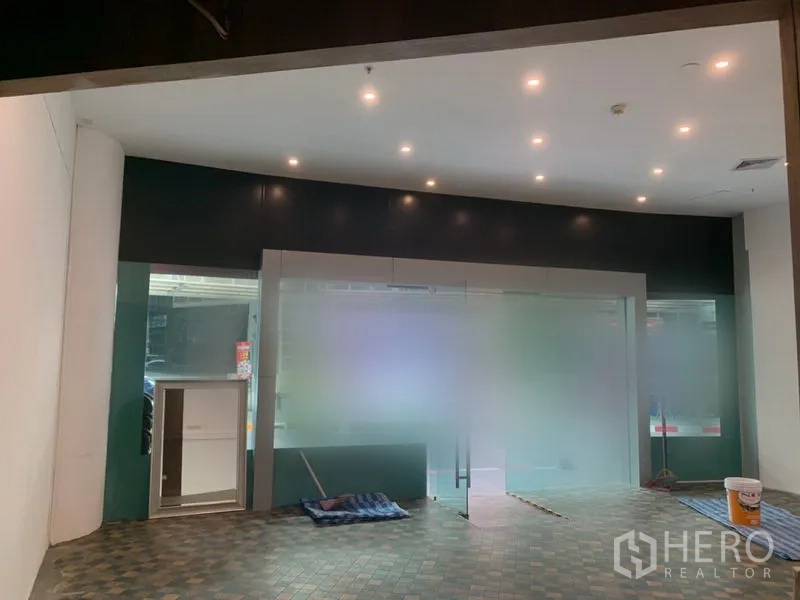 零售空间 出租在Khlong Toei, Bangkok - 店铺前区，磨砂玻璃立面与整排天花筒灯。