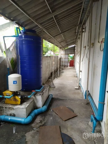 Office Space for rent in Saphan Sung, Bangkok - Covered service walkway with blue water tank, pump and exposed piping