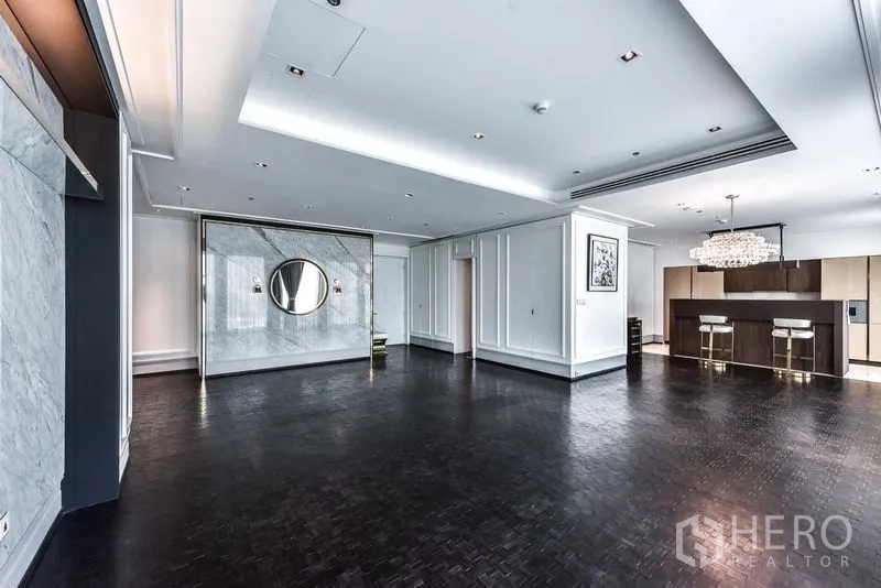 公寓 出租在Bang Rak, Bangkok - 开阔客厅与厨房相连，吊灯与深色人字拼地板。