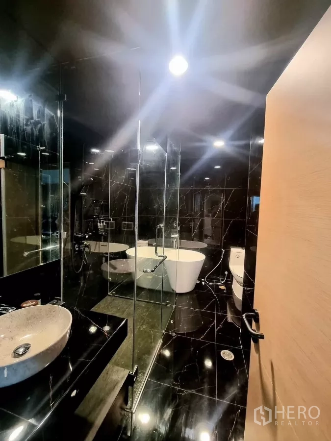 คอนโด ให้เช่าในBang Kapi, Bangkok - ห้องน้ำหรูหราปูกระเบื้องหินอ่อนดำ มีตู้กระจก อ่างล้างหน้า และอ่างอาบน้ำเดี่ยว