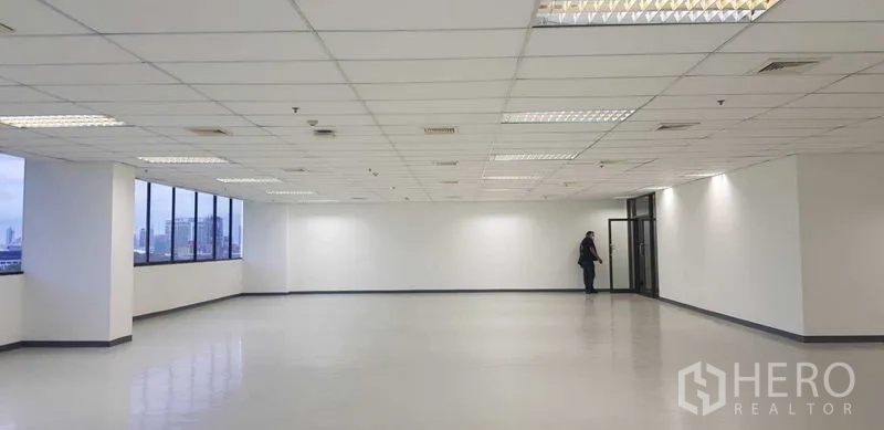 Office Space for rent in Khlong Toei, Bangkok - Open workspace with expansive windows bringing natural light and skyline views, smooth flooring and grid ceiling.