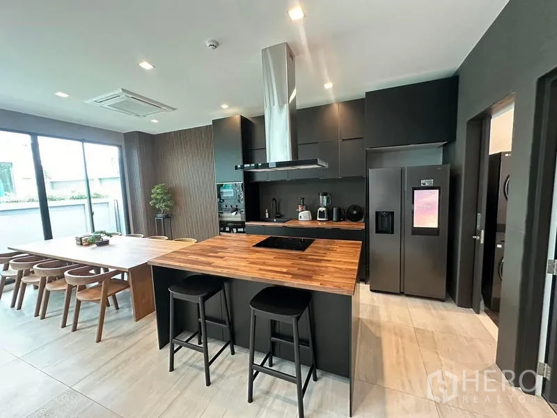 บ้าน ให้เช่าในSaphan Sung, Bangkok - ห้องครัวโมเดิร์น ไอส์แลนด์ท็อปไม้ ตู้สีเข้ม และเครื่องใช้บิวท์อิน