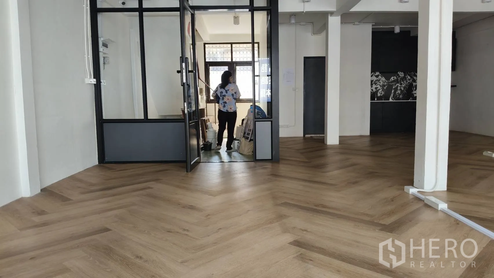 Retail Space for rent in Watthana, Bangkok - Glass double-door entrance leading to an open retail floor with wood herringbone pattern.