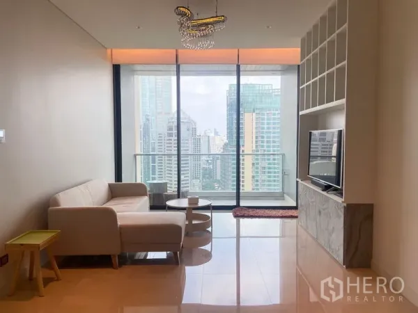 คอนโด ให้เช่าในPathum Wan, Bangkok - ห้องนั่งเล่นสว่างพร้อมกระจกเต็มผนัง ระเบียง และวิวสกายไลน์ใจกลางกรุงเทพฯ