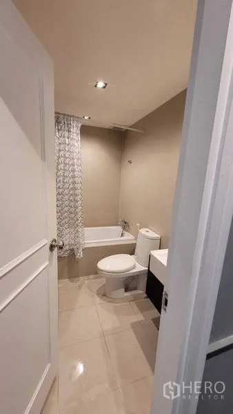 คอนโด ให้เช่าในKhlong Toei, Bangkok - ห้องน้ำคอนโดสมัยใหม่พร้อมอ่างอาบน้ำ โถสุขภัณฑ์ และเคาน์เตอร์ล้างหน้า ไฟดาวน์ไลท์