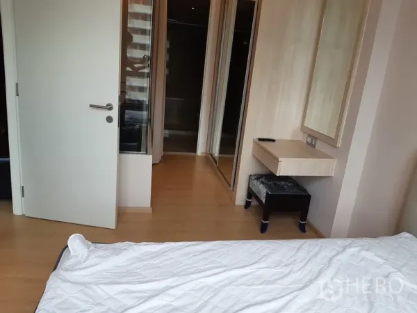 Condominium for rent in Watthana, Bangkok - Bedroom corner with built-in wardrobe, wall mirror, and small dressing desk.