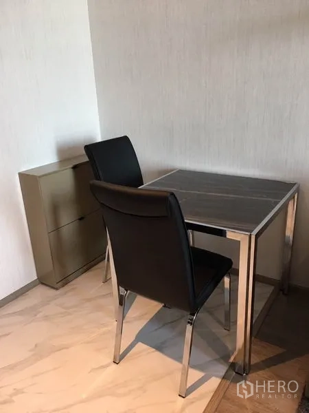 Condominium for rent in Watthana, Bangkok - Dining nook for two with black chairs and a square table.