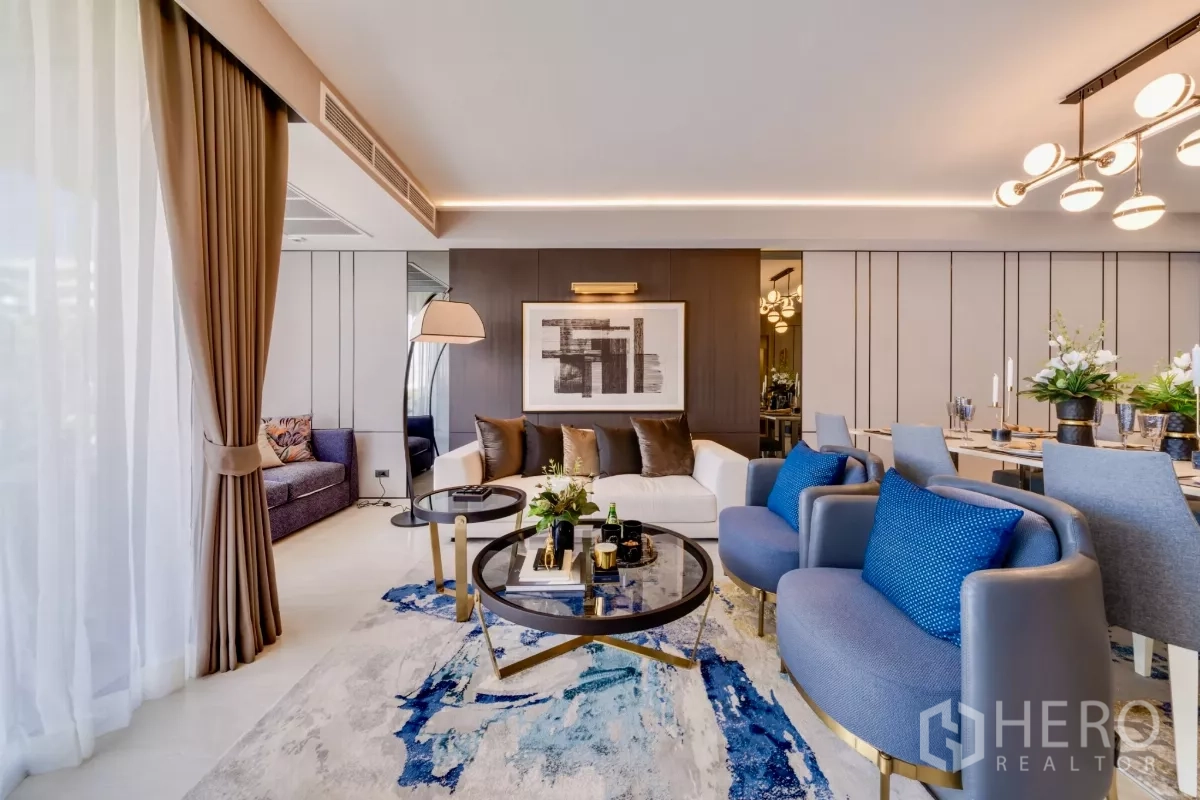 คอนโด ให้เช่าในWatthana, Bangkok - ห้องนั่งเล่นสไตล์โมเดิร์น โซฟาสีขาว เก้าอี้สีน้ำเงิน และโต๊ะกลางกระจกทรงกลม