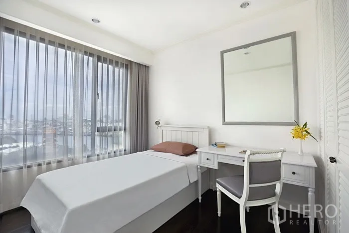 Condominium for rent in Khlong San, Bangkok - Compact bedroom with single bed, study desk and a large window.