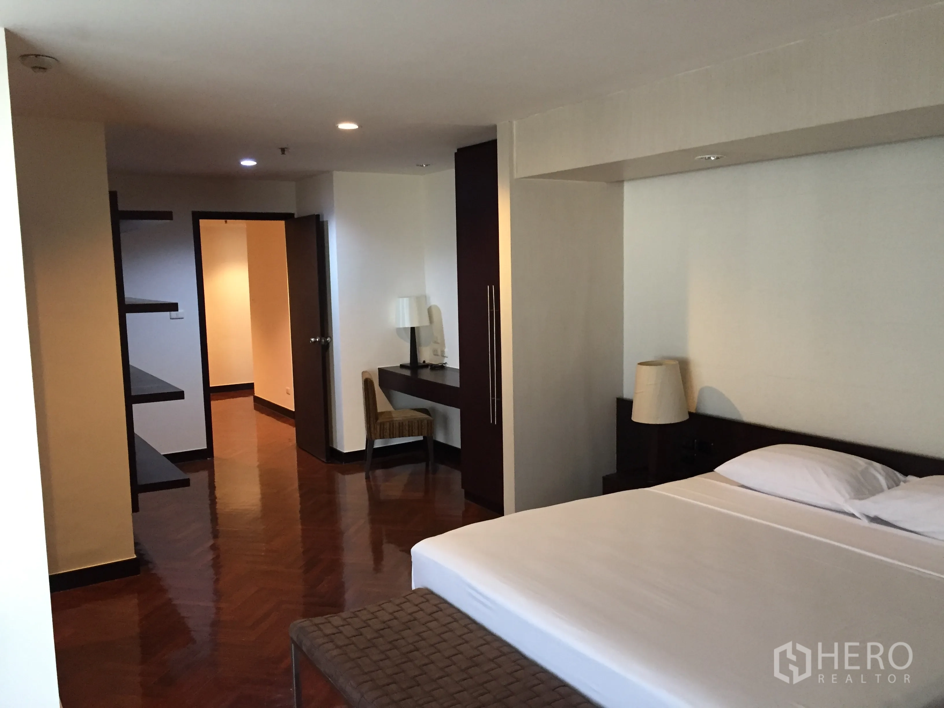 Condominium for rent in Watthana, Bangkok - Bedroom angle showing king bed, floating shelves and work desk.