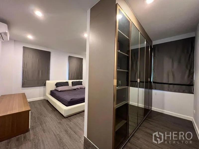 独立式住宅 出售在Bang Kruai, Nonthaburi - 主卧套房，深色窗帘，大型玻璃门衣柜与木地板。