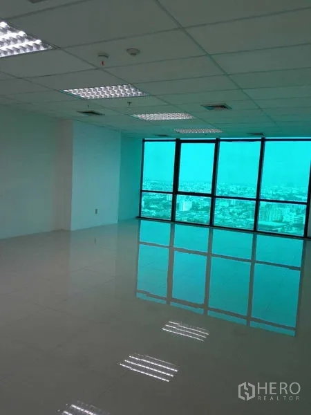 Office Space for rent in Huai Khwang, Bangkok - Spacious work area with turquoise-tinted panoramic windows overlooking the city skyline.