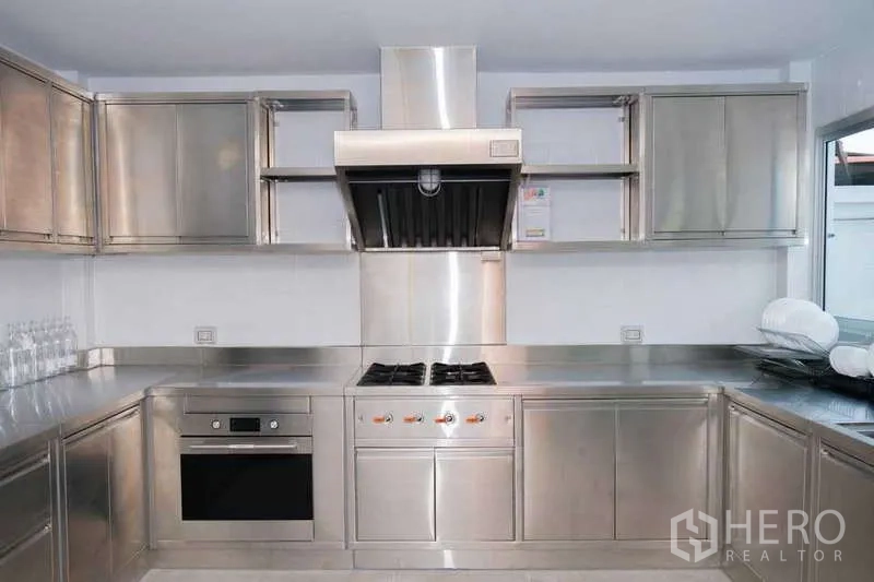 Home Office for rent in Phra Khanong, Bangkok - Professional stainless-steel kitchen with gas hob, oven, range hood and ample cabinetry.