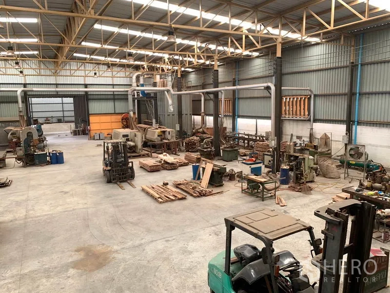 Home Office for rent in Lam Luk Ka, Pathum Thani - Panoramic view of factory floor with forklifts, machines and wide aisles.