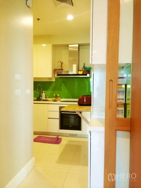 คอนโด ให้เช่าในKhlong Toei, Bangkok - ครัวยุคใหม่ขนาดกะทัดรัด ตู้สีขาว เตาอบบิวท์อิน และกระจกกันเปื้อนสีเขียว