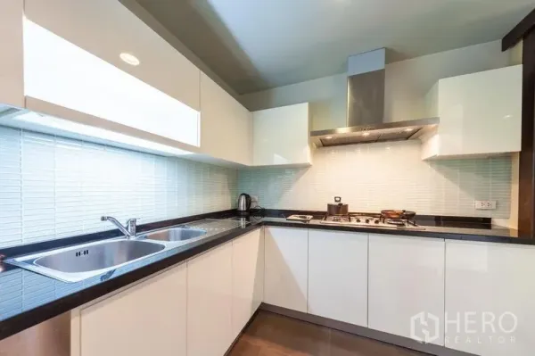 คอนโด ให้เช่าในWatthana, Bangkok - ครัวรูปตัวแอลตู้สีขาว เตาแก๊ส เครื่องดูดควัน และอ่างล้างจานคู่