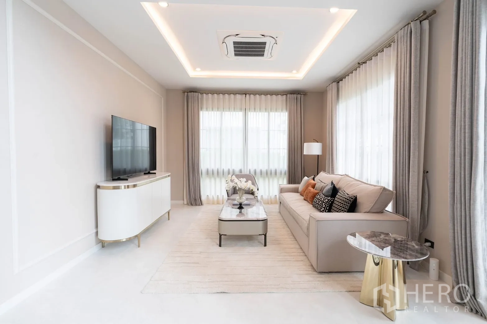 Detached House for rent in Bang Phli, Samut Prakan - Symmetrical living lounge with large windows, neutral sofa, and TV unit.