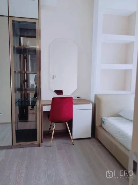 คอนโด ให้เช่าหรือขายในWatthana, Bangkok - มุมห้องนอนพร้อมโต๊ะเครื่องแป้ง เก้าอี้สีแดง และตู้กระจกโชว์