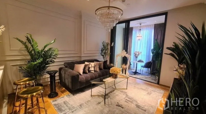 คอนโด ให้เช่าในKhlong Toei, Bangkok - ห้องนั่งเล่นทันสมัย ผนังบัว โซฟานุ่ม ต้นไม้ภายใน และโคมระย้าบนพรมสวย