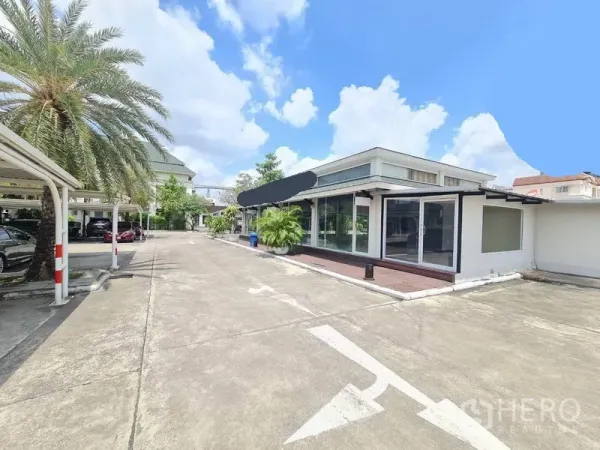 零售空间 出租在Prawet, Bangkok - 单层商铺，落地玻璃门面、木平台与宽阔车道及有顶停车位，位于曼谷 Prawet 区。