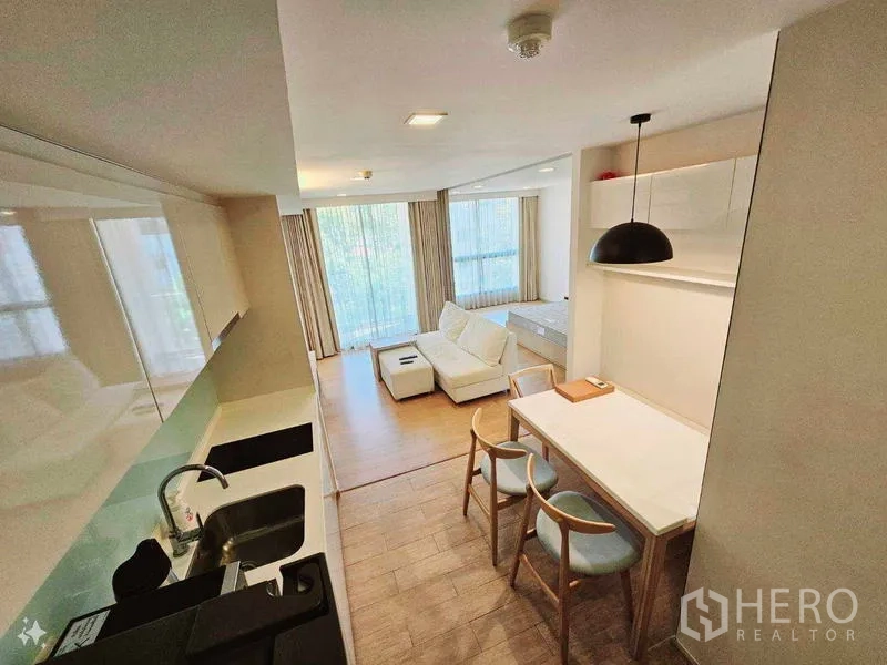 Condominium for rent - Compact fitted kitchen with sink, cooktop and dining nook beside wide windows.