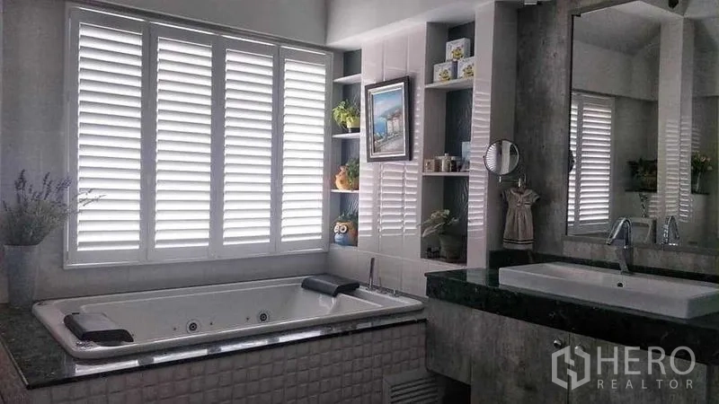Home Office for sale in Phasi Charoen, Bangkok - Bathroom with built-in jacuzzi tub, louvered windows, shelving and a wide vanity.