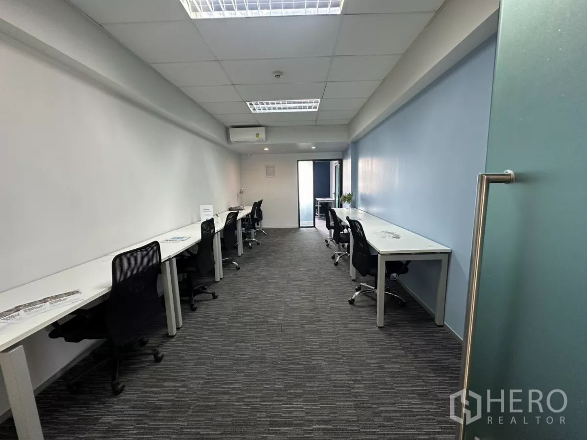 办公空间 出租在Watthana, Bangkok - 长形精装办公室，白色书桌与黑色座椅，地毯地面，尽头为玻璃门，位于通罗。