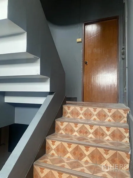 店屋 出租在Watthana, Bangkok - 楼梯间台阶贴花砖与木门，灰色墙面