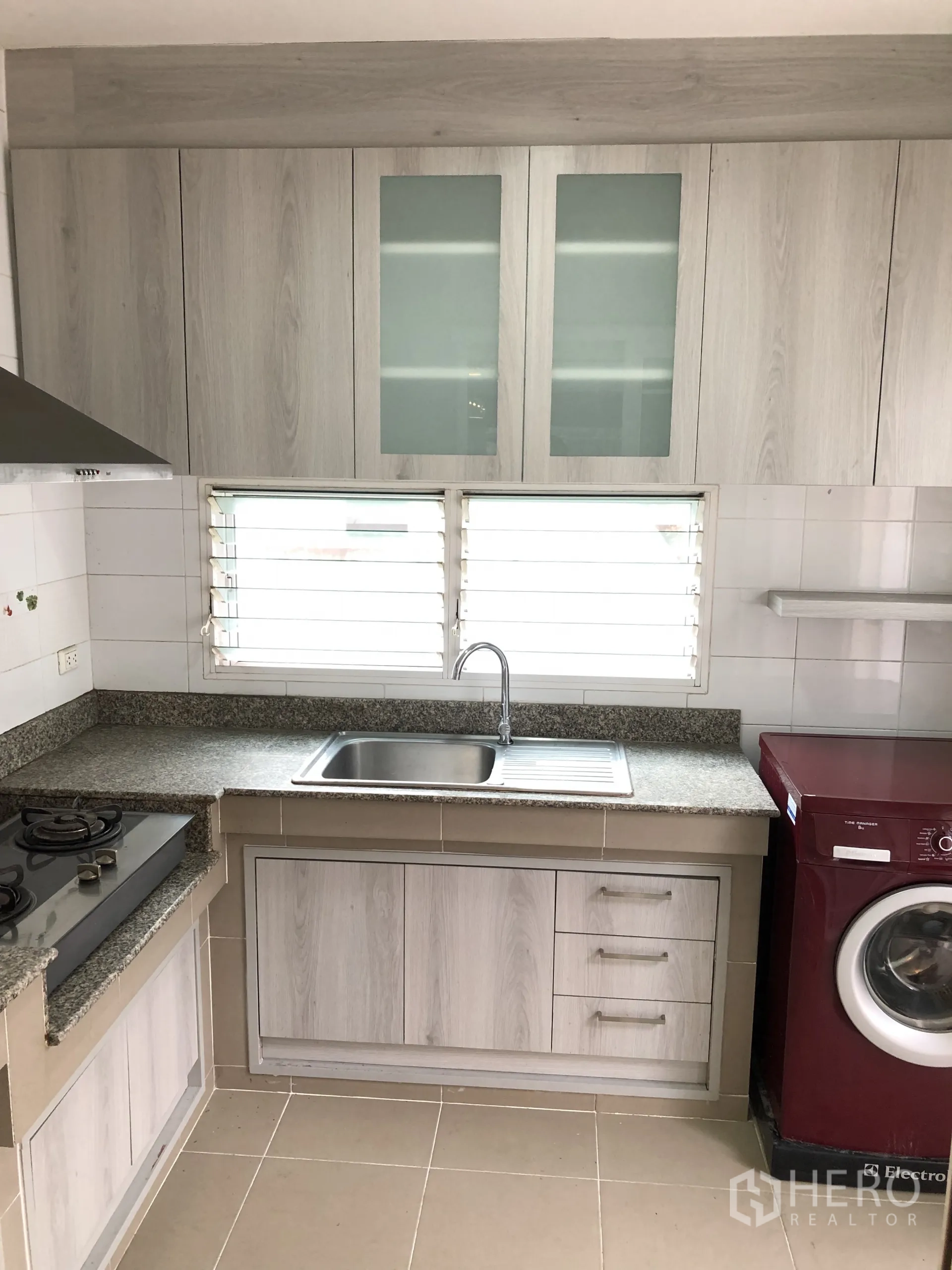 บ้าน ให้เช่าในBang Kapi, Bangkok - ตู้ครัวพร้อมอ่างล้างจาน ใต้หน้าต่างบานเกล็ด และเครื่องซักผ้า