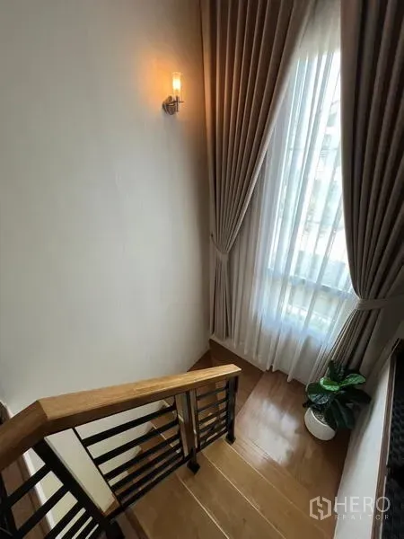 Detached House for rent or sale - Wooden staircase beside a tall draped window bringing natural light.